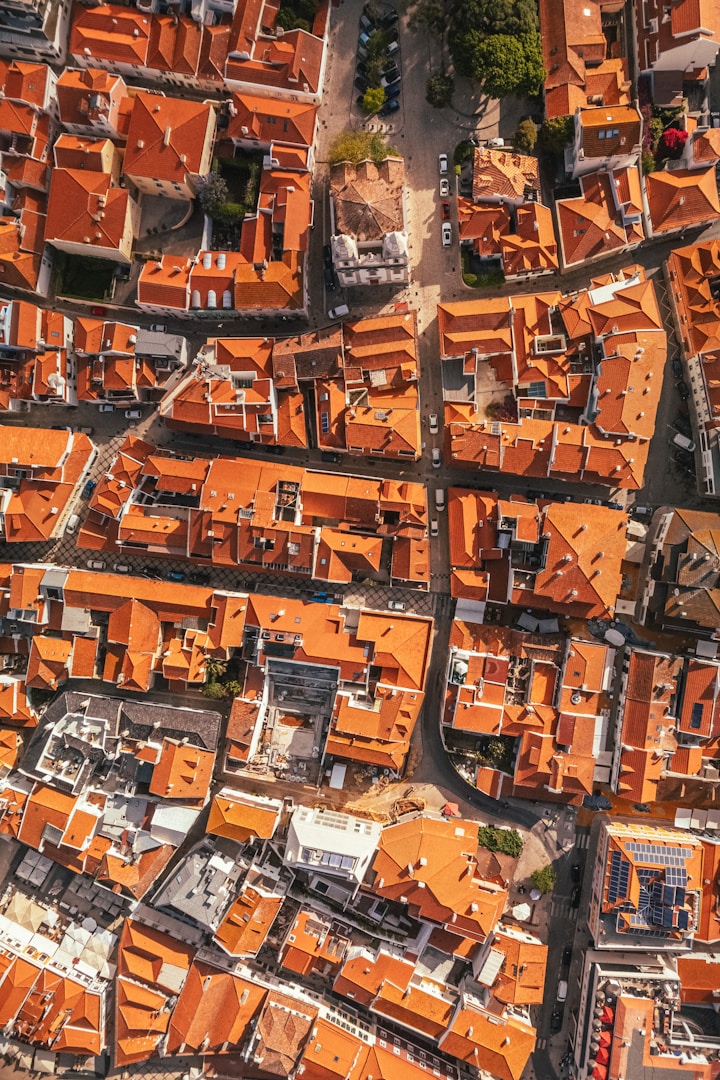 Aerial view of tightly packed buildings with orange rooftops.