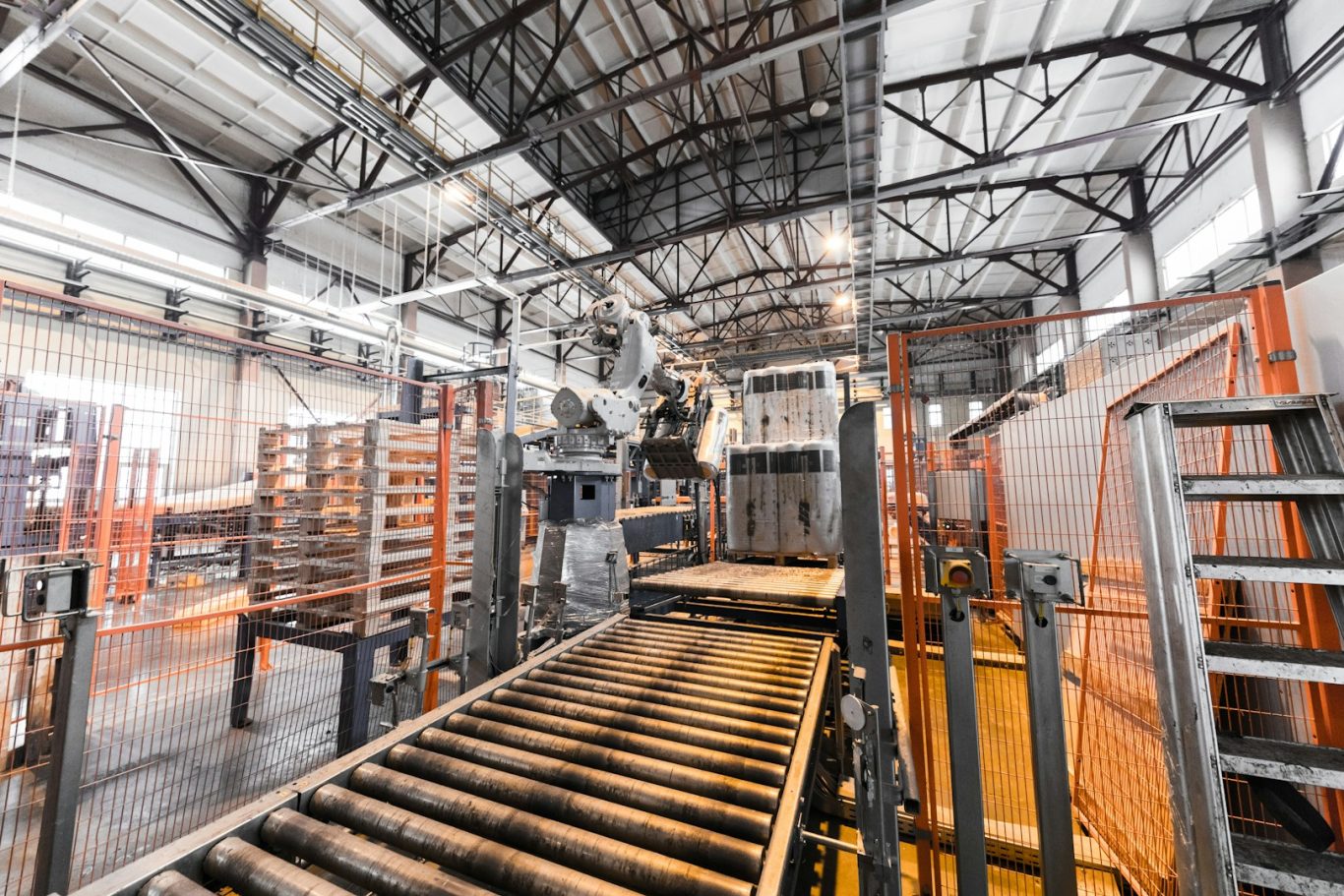 Industrial interior with conveyor belts and machinery in a spacious warehouse setting.